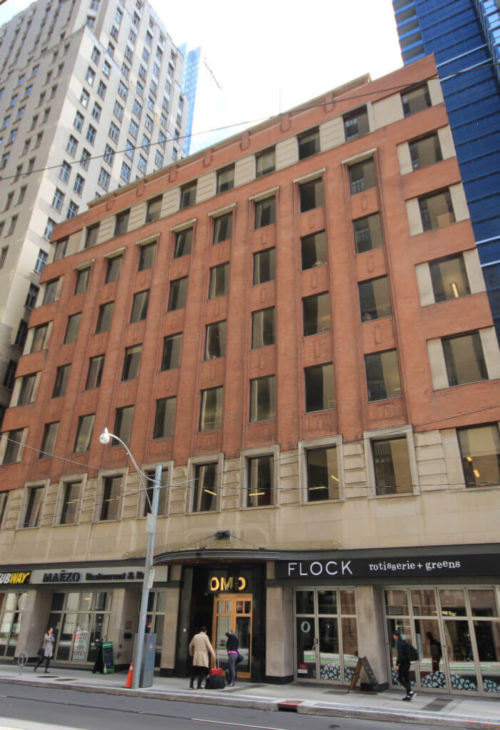 Portrait shot of Dream Office's 67 Richmond St. with people walking by on the sidewalk on an overcast day.